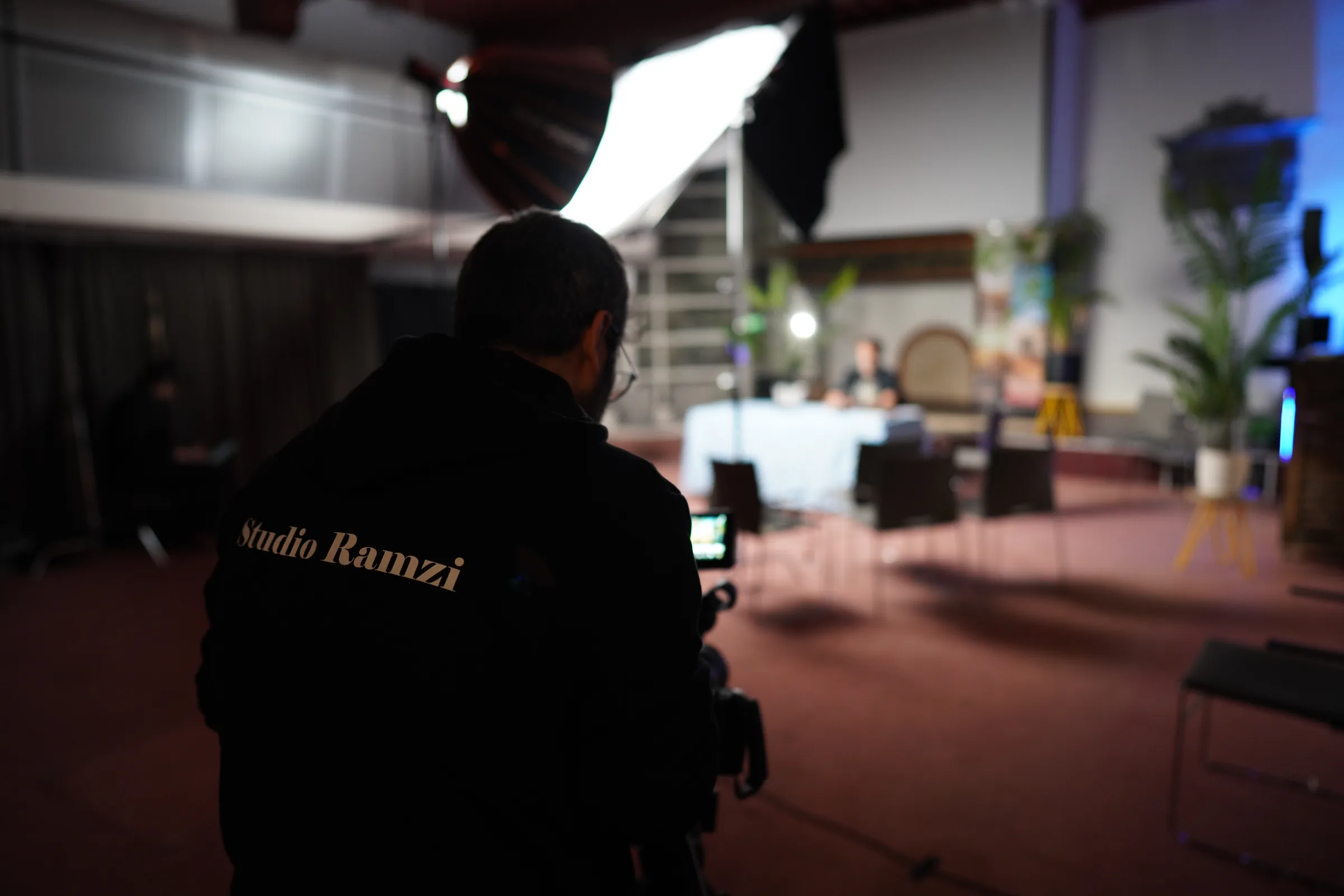 Behind the scenes: cameraman in Studio Ramzi-jas tijdens een podcastopname
