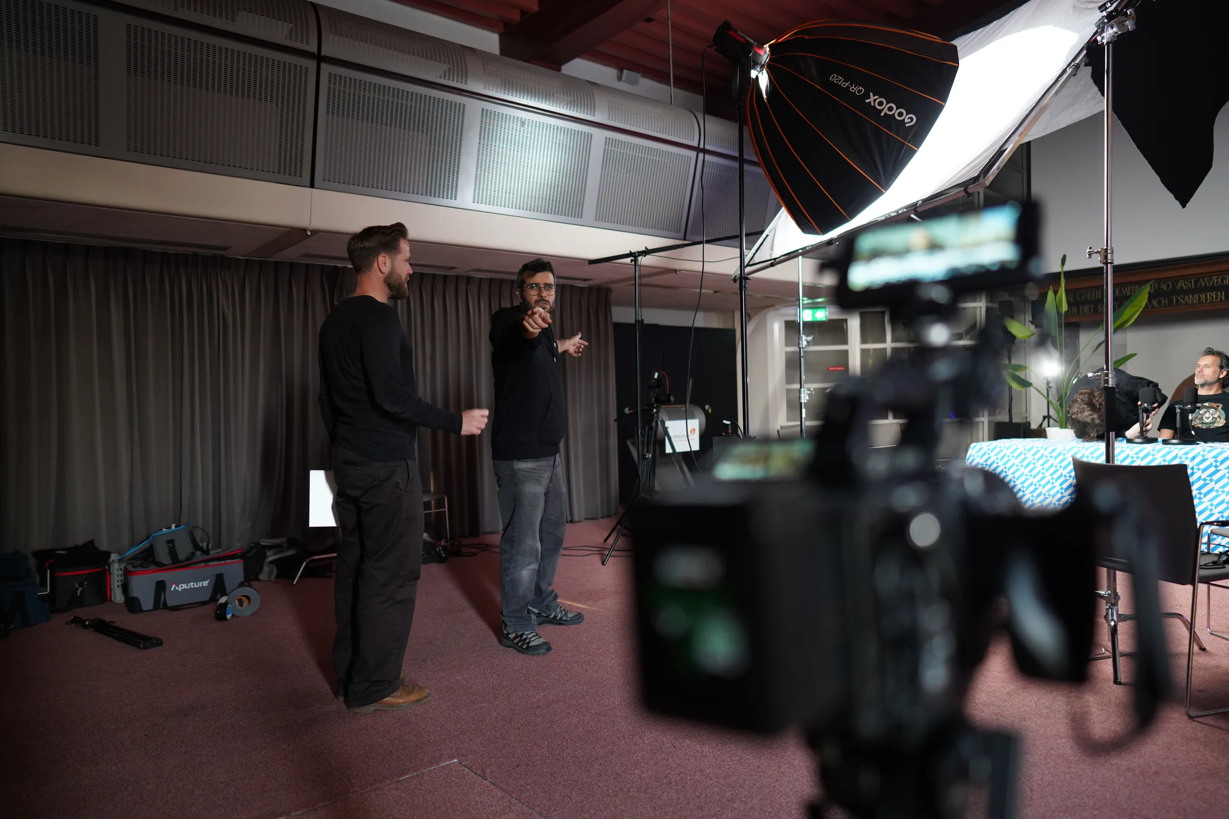 Behind the scenes: overleg op de set met camera en softbox op de voorgrond