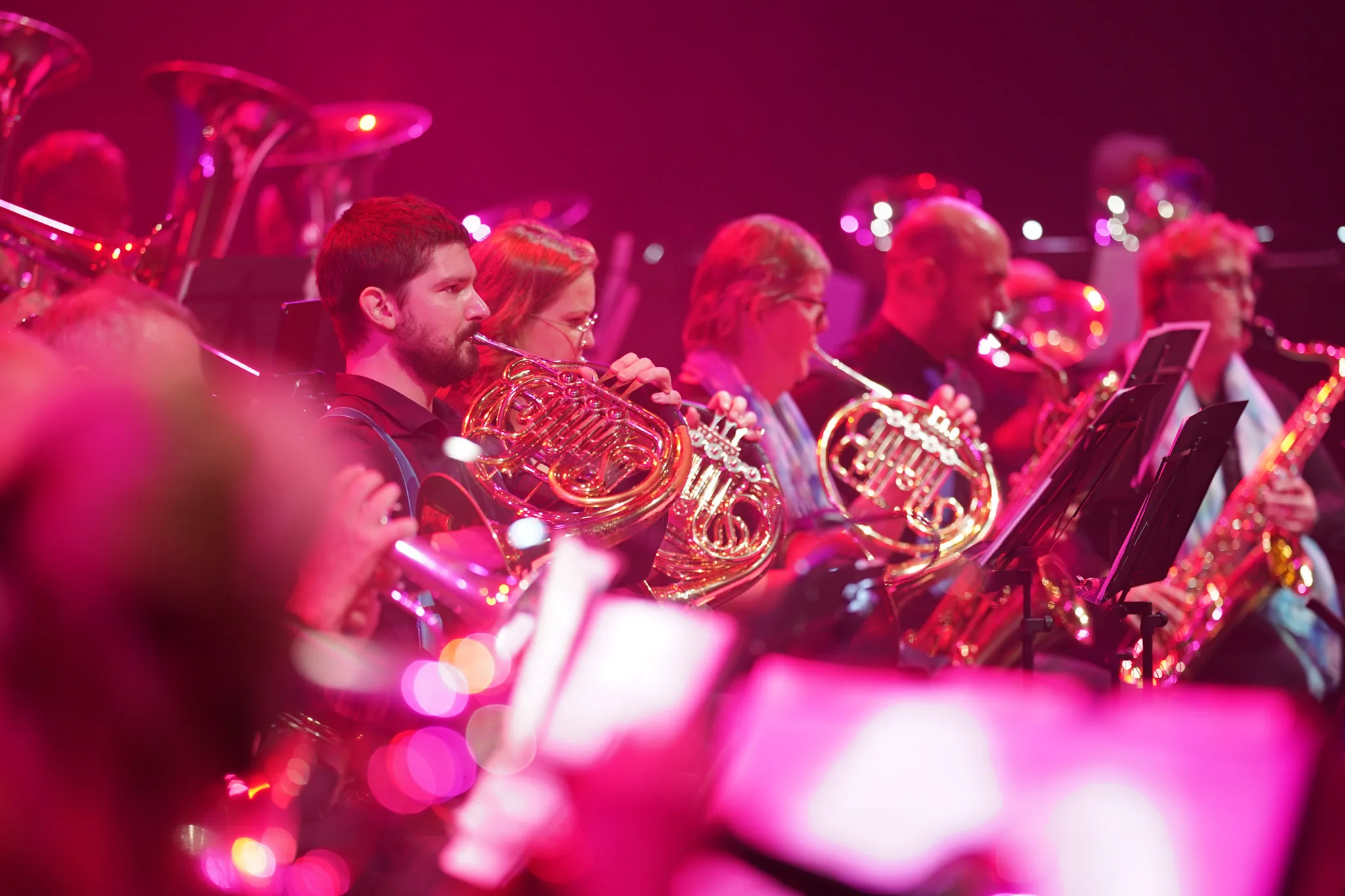 Hoornisten van een orkest in roze podiumlicht