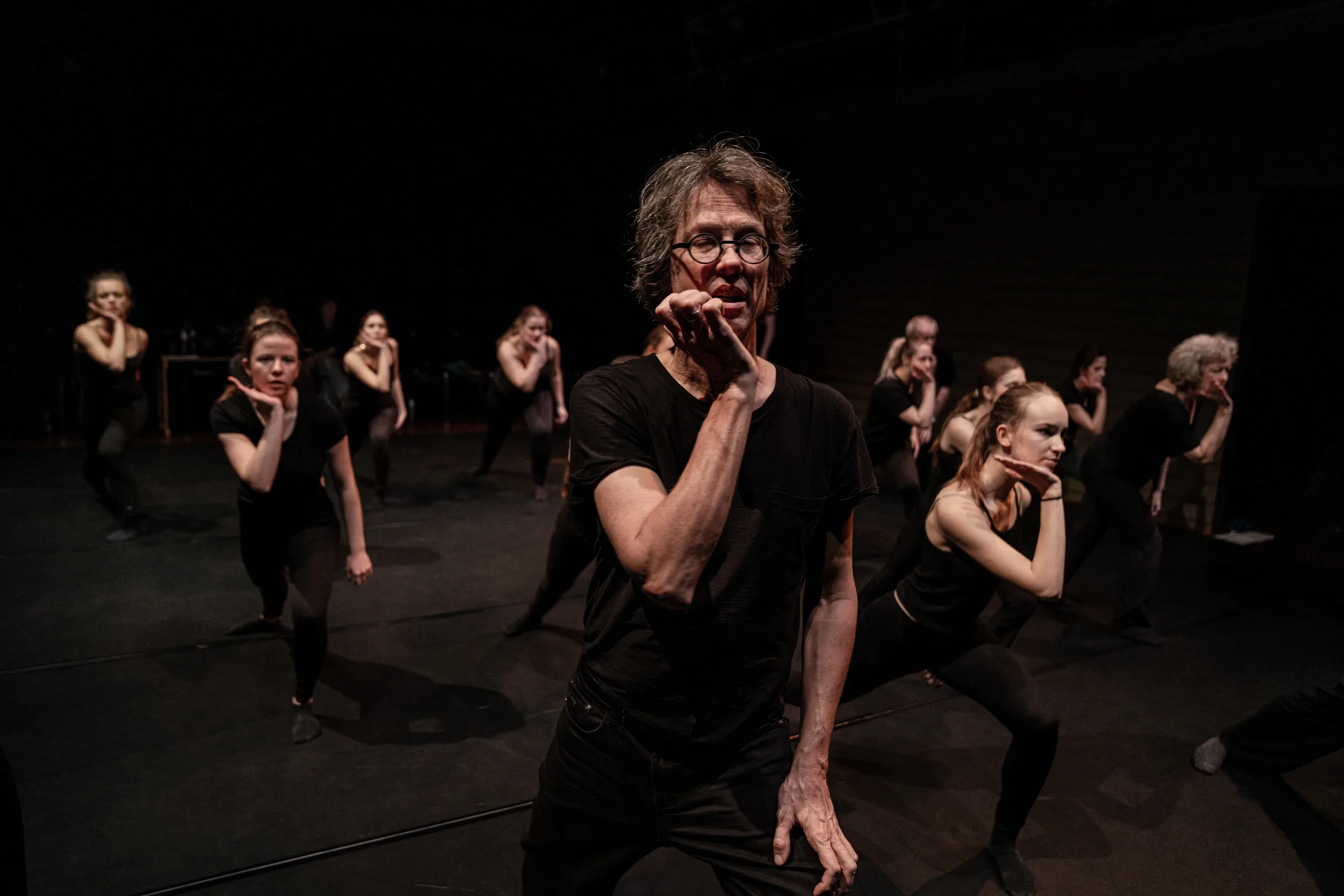 Groep dansers in het zwart tijdens een voorstelling