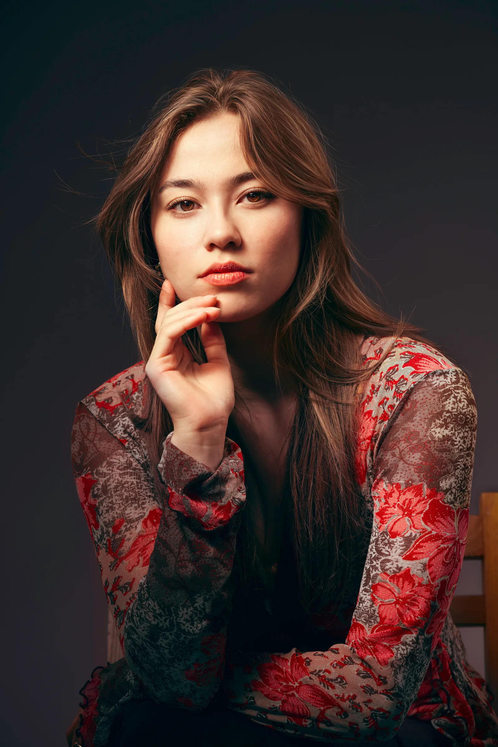 Studioportret van een vrouw met lang haar en bloemenblouse