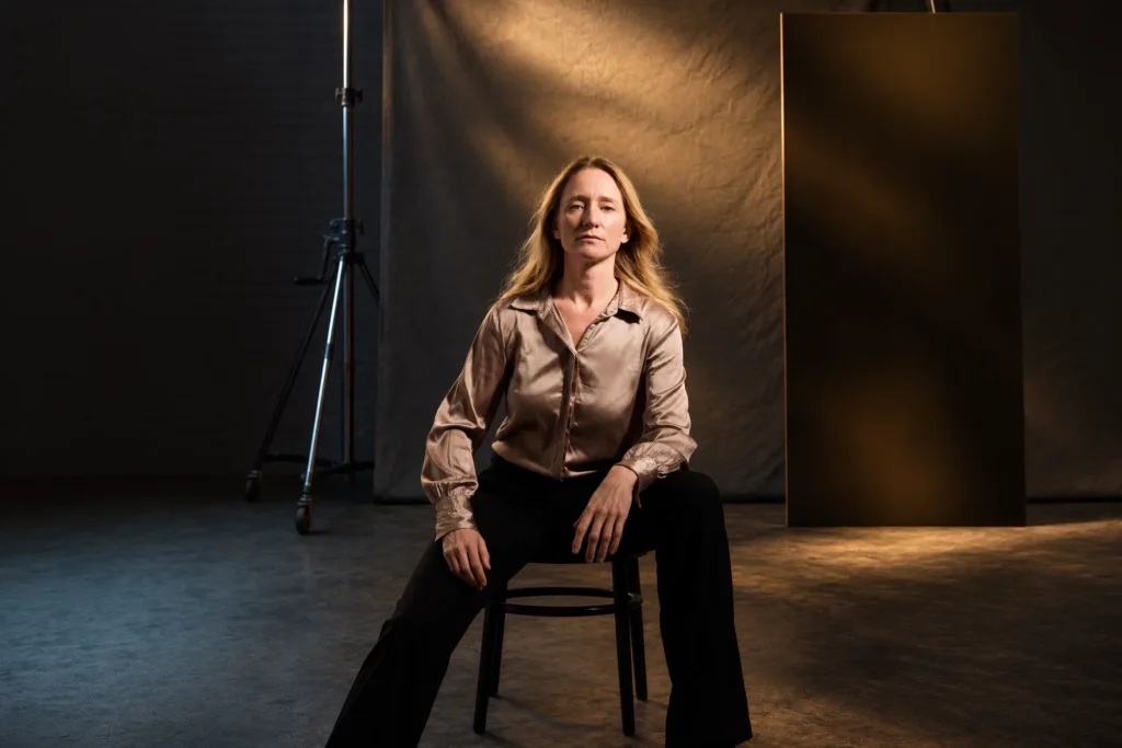 Portret van een vrouw op een stoel in warm studiolicht